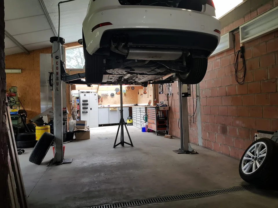 De werkplaats van Garage Gupa, met een wagen op de brug